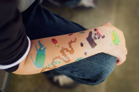Criança com tatuagens temporárias Djeco aplicadas no braço